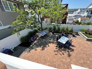 A patio with a brick floor, a hammock, and a table with chairs. - Spacious 4-bedroom house with a view of the inlet beach in North Wildwood (North Wildwood)