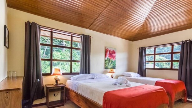 A room with two beds, a desk, and a chair. - Casa Madonna Hotel (Monteverde)