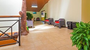 A spacious room with a high ceiling, a wooden staircase, and a seating area with chairs and a table. - Casa Madonna Hotel (Monteverde)