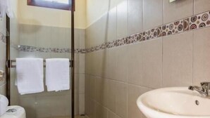 A bathroom with a toilet, sink, and shower. - Casa Madonna Hotel (Monteverde)