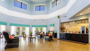 A spacious lobby with high ceilings, a central seating area, a reception desk, and a large wall map. - Near Disney Cozy 3Bd Apartment at Caribe Cove (Kissimmee)