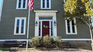 A two-story building with a red door, white windows, and an American flag. - Superb 4-bedroom historical house in Fredericktown (Fredericktown)