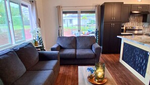 En moderne stue med sofa, sofabord og loftventilator.
