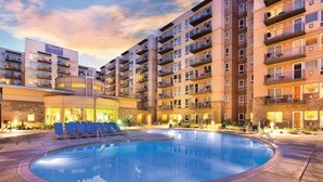 A modern hotel with a pool area, multiple balconies, and a stone facade. - Seaside Beachfront, Spring Break, beautiful, welcoming Condo. STEPS TO THE BEACH (Seaside)