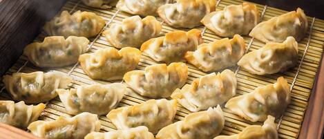 Primer plano de un método de cocina tradicional con alimentos dispuestos sobre una estera de bambú.