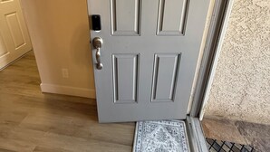 Una puerta blanca con un picaporte plateado y una cerradura pequeña.