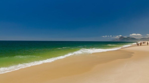 On the beach, white sand, sun loungers, beach umbrellas
