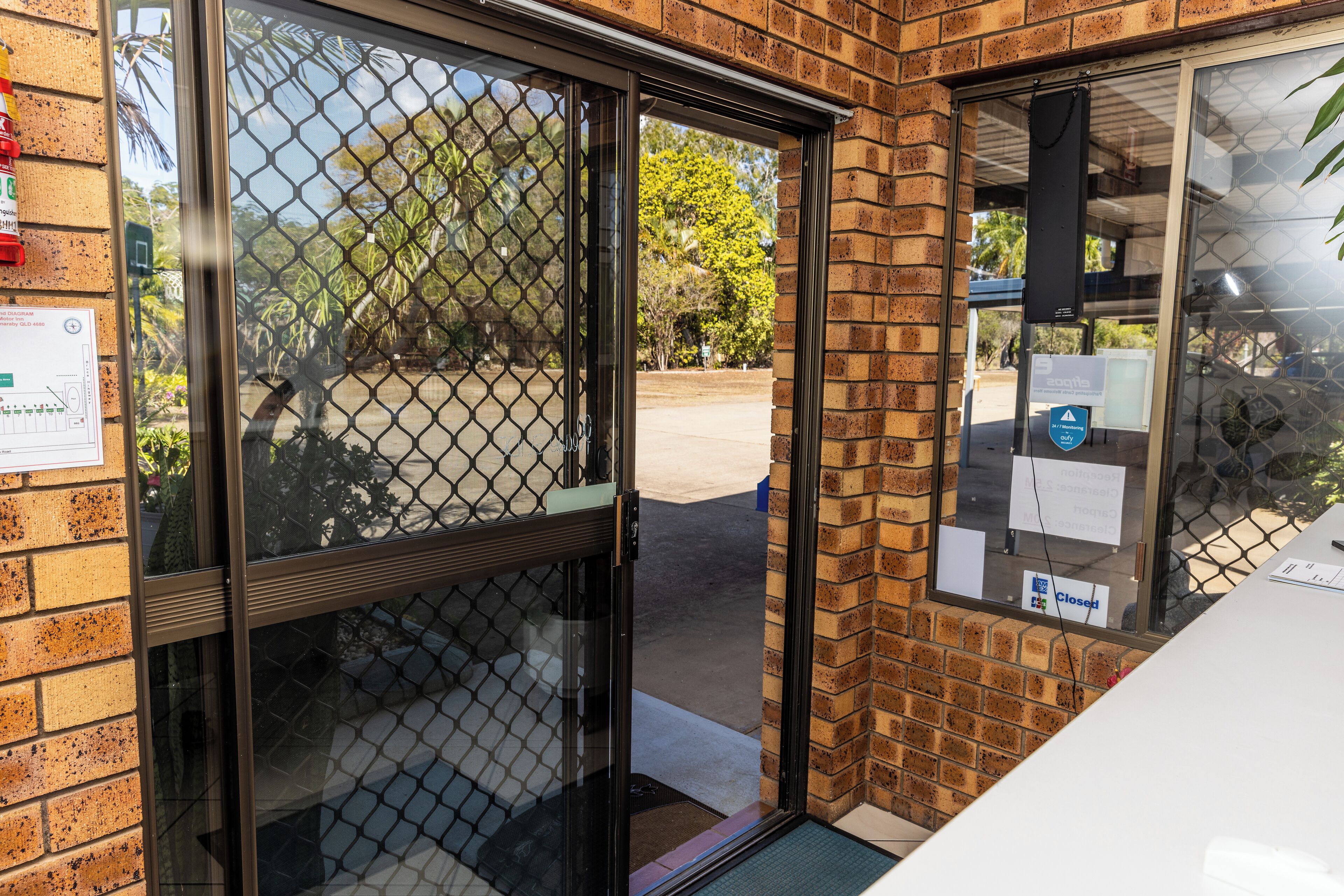 A brick building with a glass door and a metal gate.