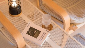 Een leeshoek met een boek getiteld 'Around' en een lamp op een geweven dienblad.
