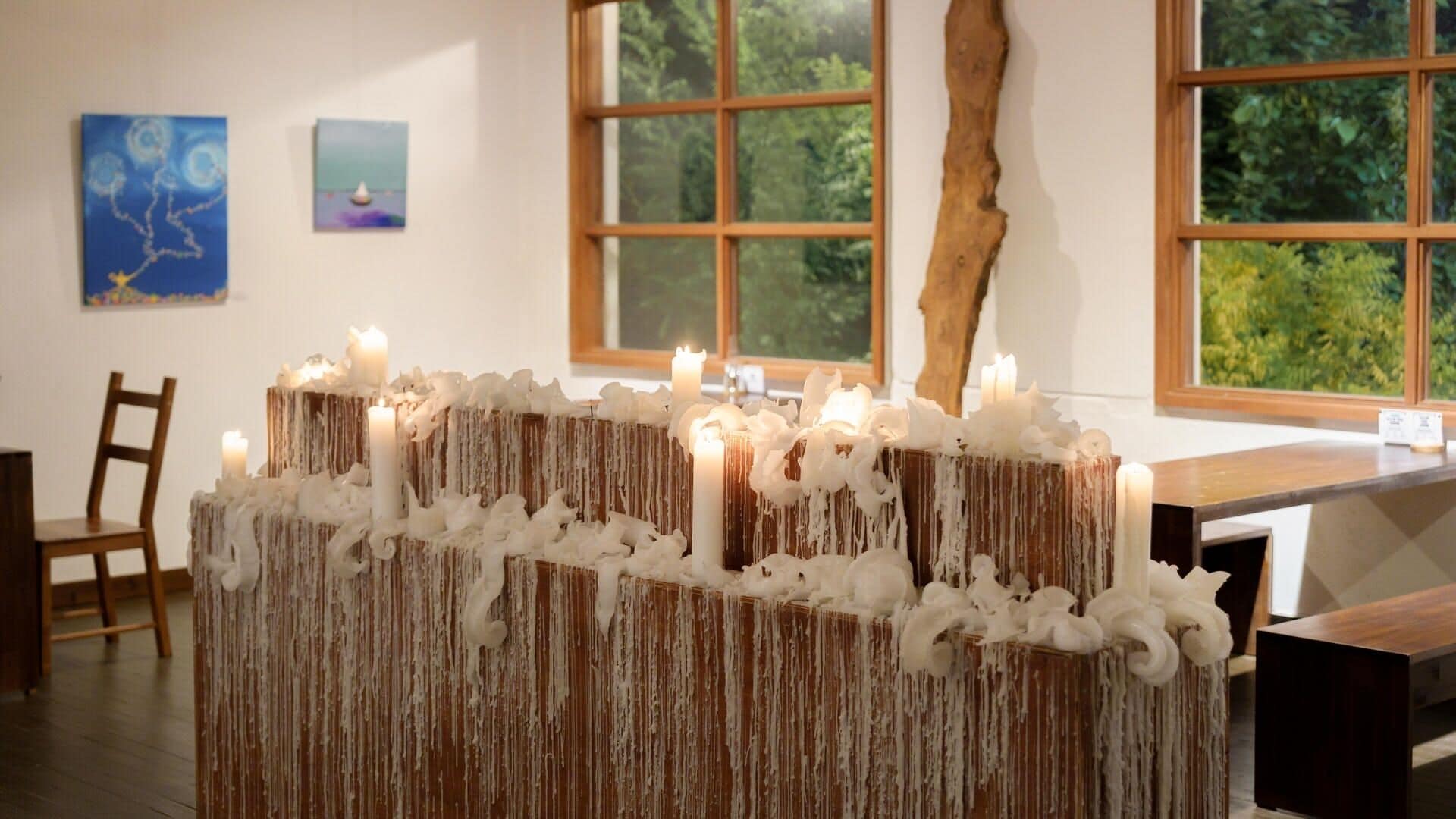 Una habitación con una mesa de madera, sillas y una ventana con vistas a zonas verdes.