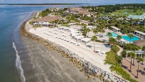 Een kustresort met een strand, een zwembad en meerdere gastvrijstaande villa's.