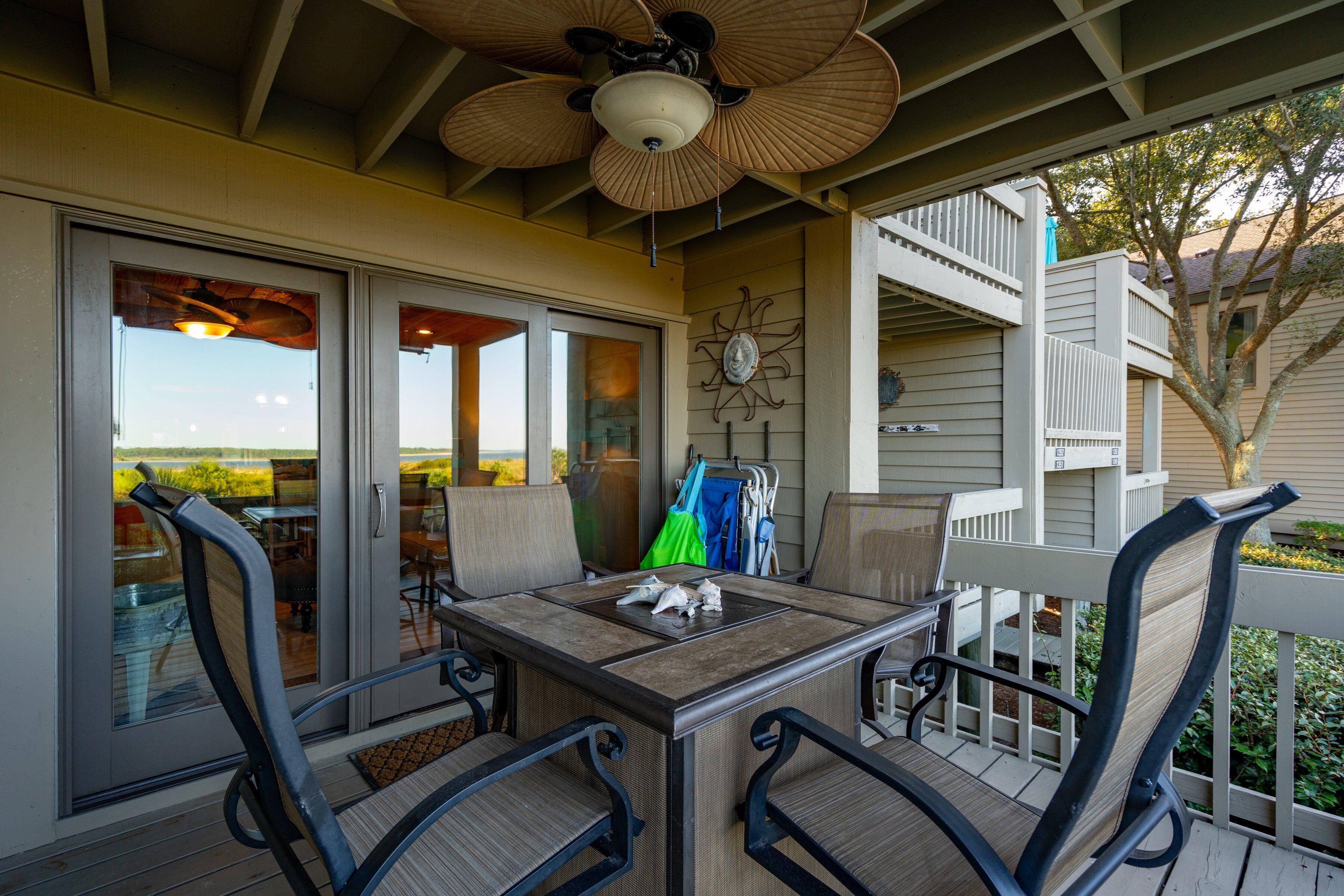 A covered patio with a table and chairs, a ceiling fan, and a view of the outdoors.
