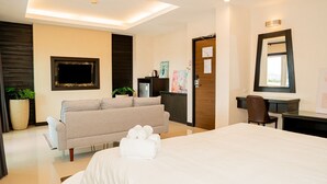 Una habitación de hotel con una cama, un sofá, un escritorio y un espejo.