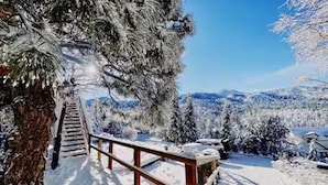 A snow-covered outdoor area with a wooden bench and a staircase leading up to a higher level. - L'Après Chalet · Bear Mtn Views · Sleeps 6 · Pet-Friendly (Big Bear Lake)