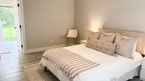 A bedroom with a bed, a nightstand, a chair, and a view of the outdoors. - 3 Bedroom Sunny Cape Coral Escape, 3 blocks from Lee Health, no cleaning fee! (Cape Coral)