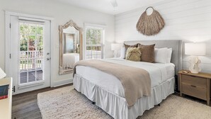 A bedroom with a bed, bedside tables, a ceiling fan, and a large mirror.
