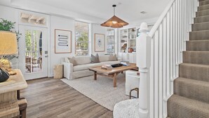 A spacious living room with a sofa, coffee table, and a staircase.