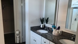 A modern bathroom with two sinks, a large mirror, and a walk-in shower. - Fabulous 4-bedroom house with AC in Riverside (Riverside)
