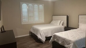 A bedroom with two beds, a ceiling fan, and a window with blinds. - Fabulous 4-bedroom house with AC in Riverside (Riverside)