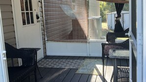 A covered porch with a door, two wicker chairs, and a view of the outdoors. - Lots of open and private space for the family and pets (Fanning Springs)