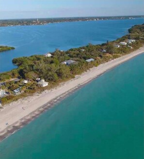An aerial view of a coastal property with a beachfront, a road along the shore, and scattered buildings. - Blue Paradise: 2BR Condo Near Englewood Beach + Pool (Englewood)