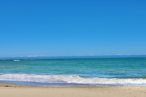Ein Strand mit klarem, blauem Wasser und einem sandigen Ufer.
