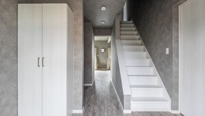 A modern interior with a staircase, a wardrobe, and a hallway leading to another room. - SASAMEYUKI (Furano)
