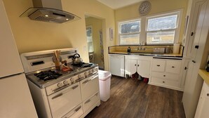 A kitchen with a stove, sink, and cabinets.