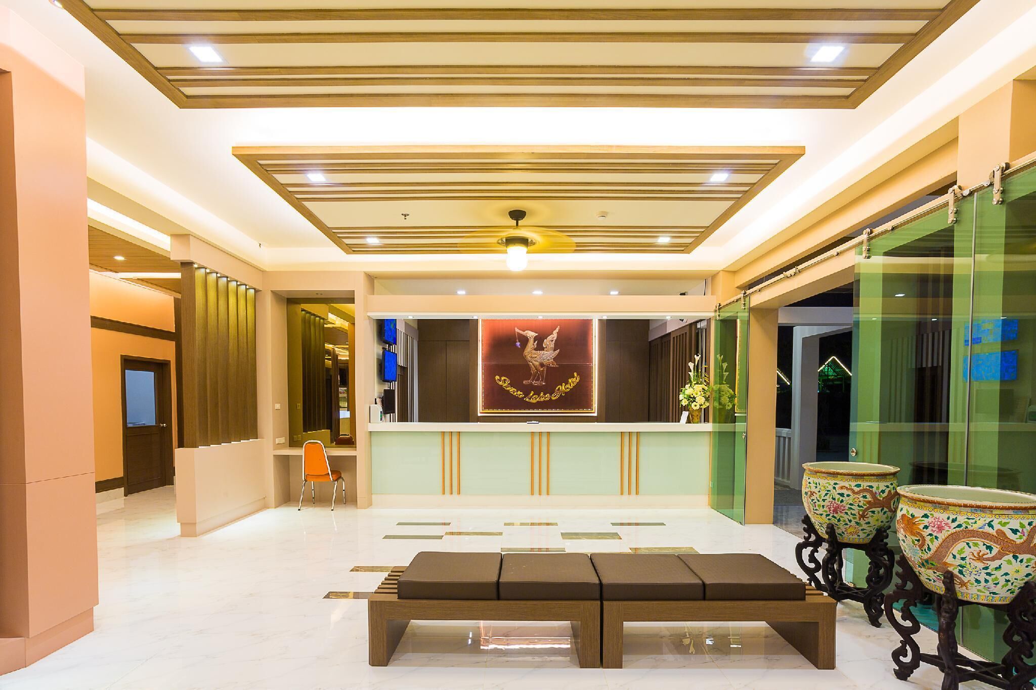 A lobby with a reception desk, a bench, and decorative vases.