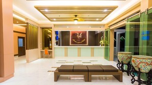 Eine Lobby mit einer Rezeption, einer Bank und dekorativen Vasen.