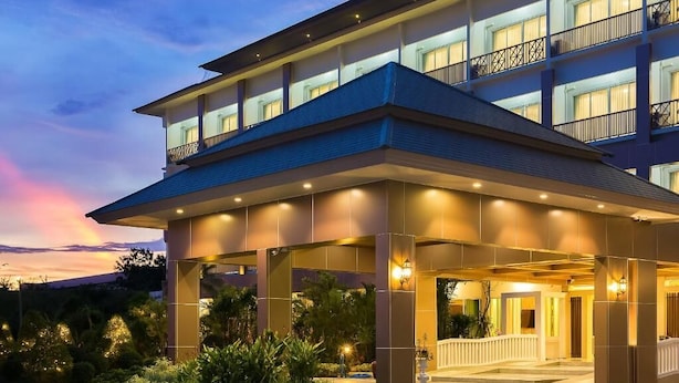 A multi-story hotel with a covered entrance, outdoor lighting, and a landscaped garden area. - Swan Lake Hotel Sattahip (Sattahip)