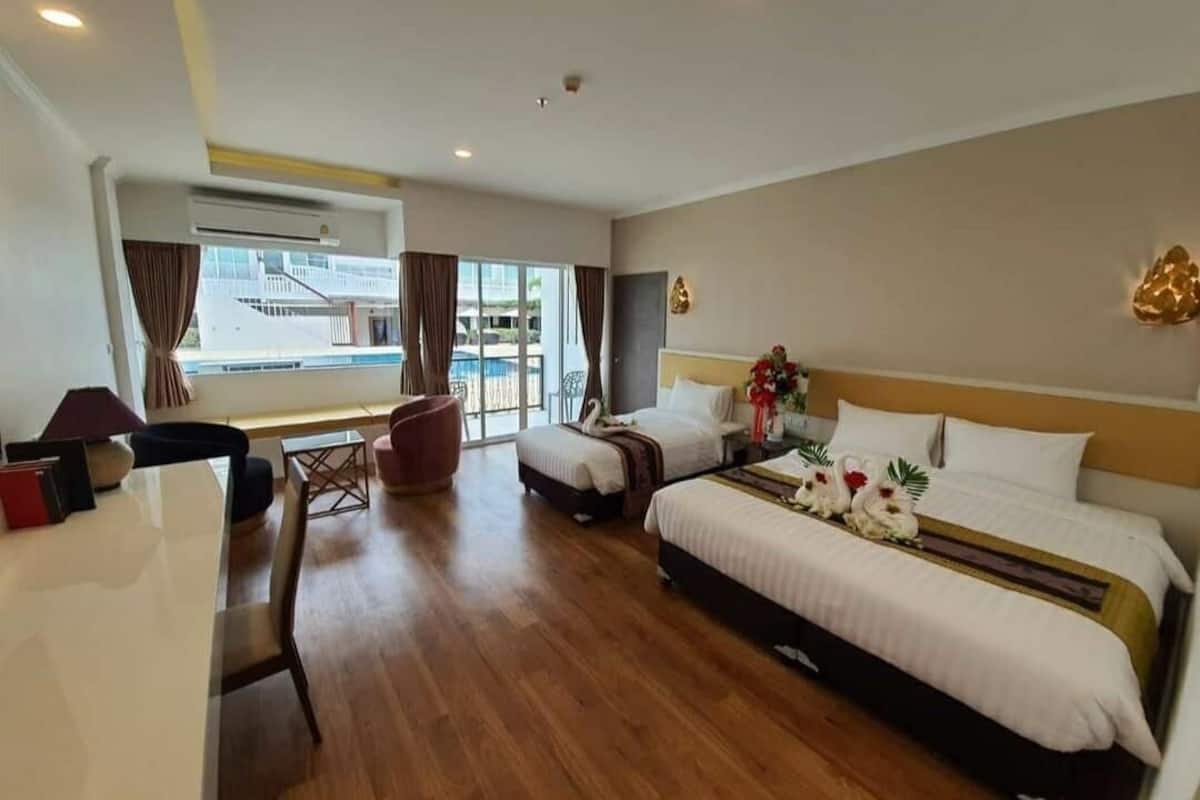 Une chambre d’hôtel avec un grand lit, un bureau, une chaise et une vue sur l’extérieur.