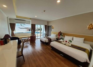 Ein Hotelzimmer mit einem großen Bett, einem Schreibtisch, einem Stuhl und Blick ins Freie.