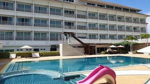 A hotel with a swimming pool, a slide, and a multi-story building with balconies. - Swan Lake Hotel Sattahip (Sattahip)