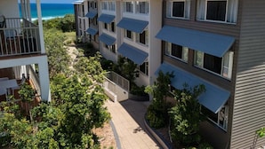 A multi-story hotel with balconies overlooking a beach.