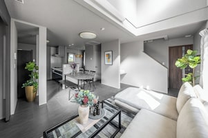 A modern living room with a sofa, coffee table, and potted plants.