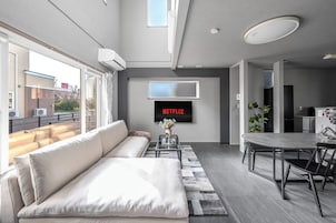 Una sala de estar moderna con sofá, mesa de centro y comedor.