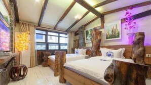 Una habitación con dos camas, cabeceros de madera, una ventana y un cuadro en la pared.
