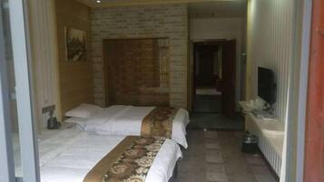 Een hotelkamer met twee bedden, een televisie en een badkamer die door een open deur zichtbaar is.