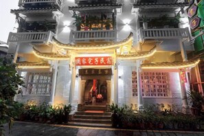 Un edificio tradicional con una estructura escalonada, una entrada central con escalones y un cartel sobre la entrada.