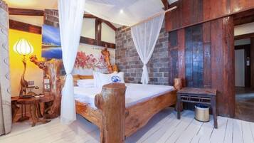 Un letto di legno con baldacchino, un comodino, una lampada e un quadro appeso al muro.