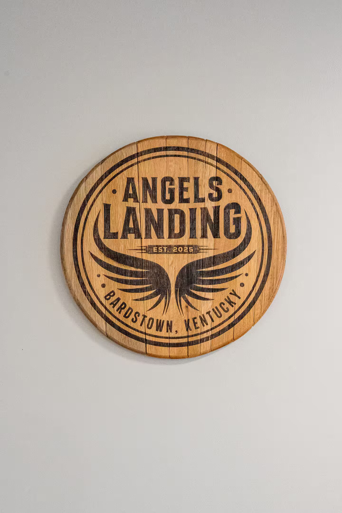 Une plaque circulaire en bois portant les inscriptions gravées « Angels Landing » et « Bardstown, Kentucky ».