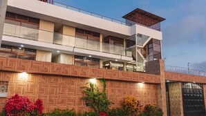 A multi-story building with a modern architectural design, featuring balconies, large windows, and a brick facade.
