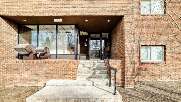 A brick building with a covered entrance, outdoor seating area, and a staircase leading to the entrance. - Chinook II.
Pet Friendly 
 Nutrien ,CGC Inc Wheatland Plant, De Havilland. (Strathmore)