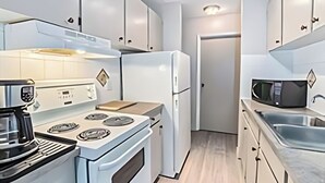 A modern kitchen with white cabinets, a stove, a microwave, and a sink. - Chinook II.
Pet Friendly 
 Nutrien ,CGC Inc Wheatland Plant, De Havilland. (Strathmore)