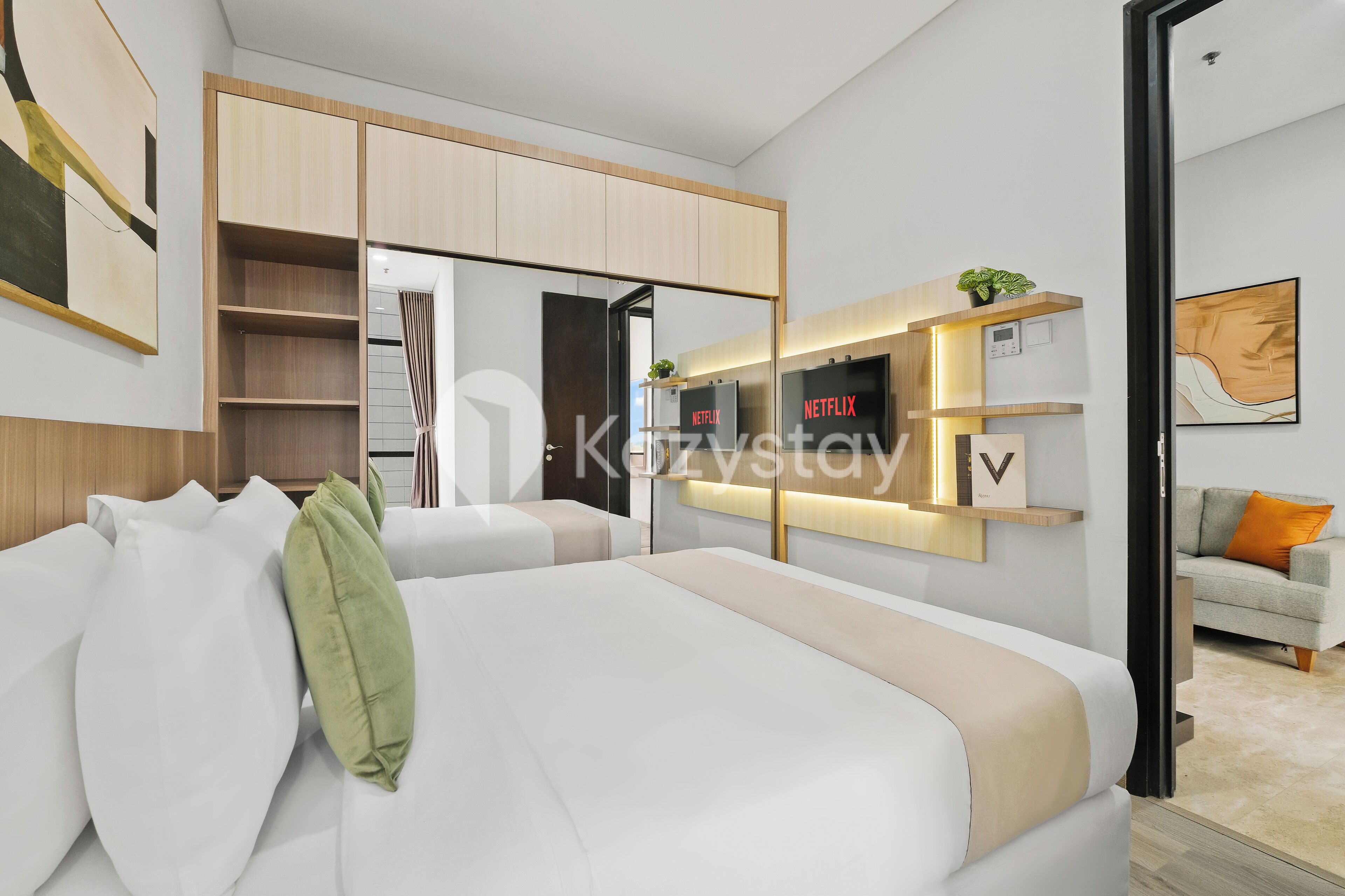 A modern bedroom with a bed, a wardrobe, a TV, and a sofa.