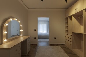 Ein Schlafzimmer mit Schminktisch, Spiegel und begehbarem Kleiderschrank.