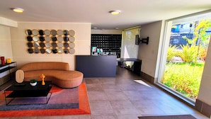 A modern living room with a sectional sofa, a coffee table, and a wall-mounted mirror display. - We have the ideal space for you in Ñuñoa (Ñuñoa)