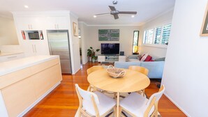 A modern kitchen with white cabinets, a built-in oven, and a stainless steel refrigerator. - Melaleuca Lookout - Modern 3-Bedroom Townhouse with Ocean Wiews (Point Lookout)