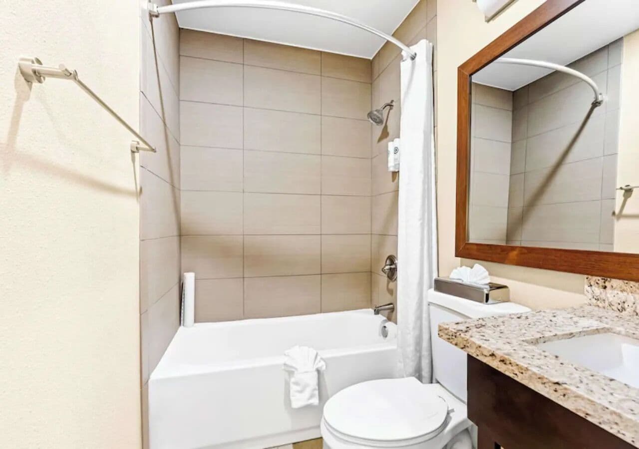 A modern bathroom with a bathtub, toilet, and a sink.